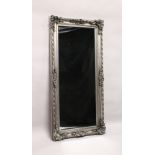 A LARGE WALL MIRROR, with moulded silver coloured frame. 5ft 7ins x 2ft 9ins.