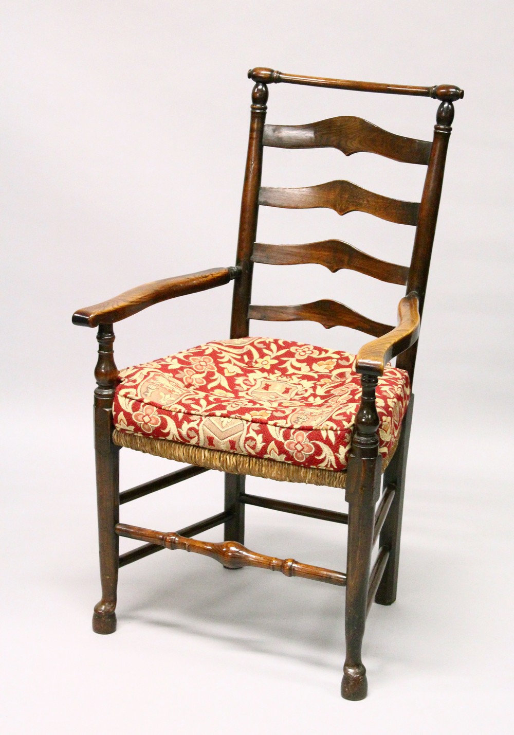 A GOOD 18TH CENTURY OAK LADDER BACK ARMCHAIR, with rushwork seat.