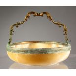 A CIRCULAR ONYX FRUIT BOWL, with metal mounts and handle. 7ins diameter.