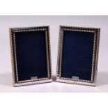 A PAIR OF SILVER AND ENAMEL BEAD EDGE PHOTOGRAPH FRAME. 7ins x 4.5ins.