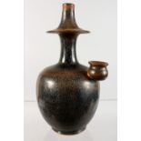 AN UNUSUAL CHINESE BROWN GLAZED EARTHENWARE BOTTLE VASE. 8.5ins high.