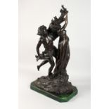 A LARGE BRONZE GROUP, a young man embracing a semi-nude standing female figure, on a shaped green