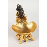 A CLASSICAL STYLE GILT BRONZE TABLE SALT, modelled as a cherub seated on a shell. 7.5ins high.