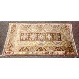 A 20TH CENTURY PERSIAN CARPET, beige ground with large stylised motifs. 8ft 0ins x 4ft 5ins.