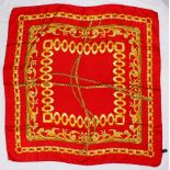 A SILK SCARF, RED WITH GOLD CHAIN.