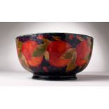 A LARGE MOORCROFT POTTERY CIRCULAR FRUIT BOWL, pomegranate and fruit on a blue ground. W.