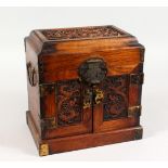 A CHINESE HARDWOOD TABLE CABINET, the hinged top and pair of doors carved with dragons. 10ins wide x