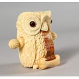 A CARVED BONE OWL TAPE MEASURE.