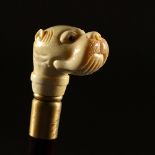A BONE HANDLE WALKING STICK, carved as a dog. 37ins long.