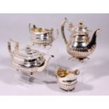 A GEORGE III AND GEORGE IV SEMI FLUTED FOUR PIECE TEA SET, with acanthus mounts, gadrooned edge