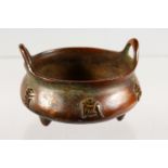 A SMALL CHINESE BRONZE TWIN-HANDLED CENSER, decorated with calligraphy. 3.5ins diameter.