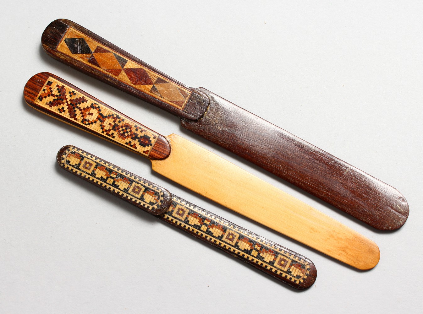 THREE TUNBRIDGE WARE PARQUETRY PAPER KNIVES. 5ins, 7ins and 7.5ins long.