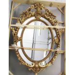 A LARGE AND IMPRESSIVE FRENCH STYLE GILT FRAMED OVAL WALL MIRROR, with highly ornate frame. 7ft 4ins