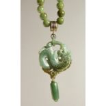 A GREEN JADE NECKLACE AND PENDANT.