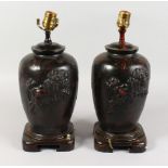 A PAIR OF CHINESE BRONZE TABLE LAMPS, each decorated with a Dog of Fo. 15ins high.