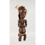 A CARVED WOOD TRIBAL SEATED FIGURE. 18ins high.