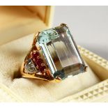 A SUPERB LARGE 14CT GOLD AQUAMARINE RING, with ruby and diamond shoulders.