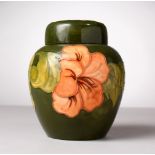 A GOOD MOORCROFT POTTERY BULBOUS GREEN GROUND GINGER JAR AND COVER, "Hibiscus". Moorcroft