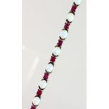 A SILVER, OPAL AND RUBY SET LINE BRACELET.