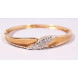 A 14CT YELLOW GOLD BRILLIANT CUT DIAMOND BANGLE with hinged clasp.