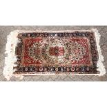 A 20TH CENTURY PERSIAN PART SILK RUG, beige ground with allover floral decoration, within a