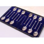 A GOOD SET OF TWELVE SEAL END SPOONS and SUGAR TONGS, in a leather case. Sheffield 1921.