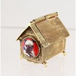 A BRASS NOVELTY DOG KENNEL, with enamel pug dog.