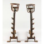 A GOOD PAIR OF WROUGHT IRON FIRE DOGS, with torchere tops and spit hooks. 28ins high.