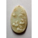 A CHINESE CARVED OVAL JADE PENDANT. 3.25ins x 1.75ins.