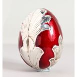 A RED ENAMEL AND SILVER EGG.