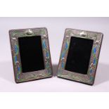 A PAIR OF SILVER AND ENAMEL ART NOUVEAU DESIGN UPRIGHT PHOTOGRAPH FRAMES. 7.5ins x 5.5ins.