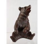 A BLACK FOREST CARVED WOOD SEATED BEAR CADDY. 8ins high.