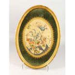 A 19TH CENTURY OVAL SILKWORK FLORAL PICTURE, framed and glazed. 22ins high.