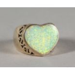 A SILVER AND OPAL HEART SHAPED RING.