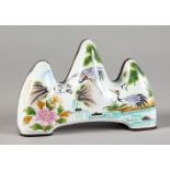 A CANTON ENAMEL BRUSH REST, painted with storks. 4ins long.