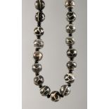 A STRING OF BLACK AND WHITE BEADS.
