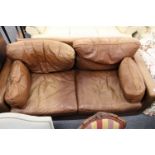 A modern brown leather two seater sofa.