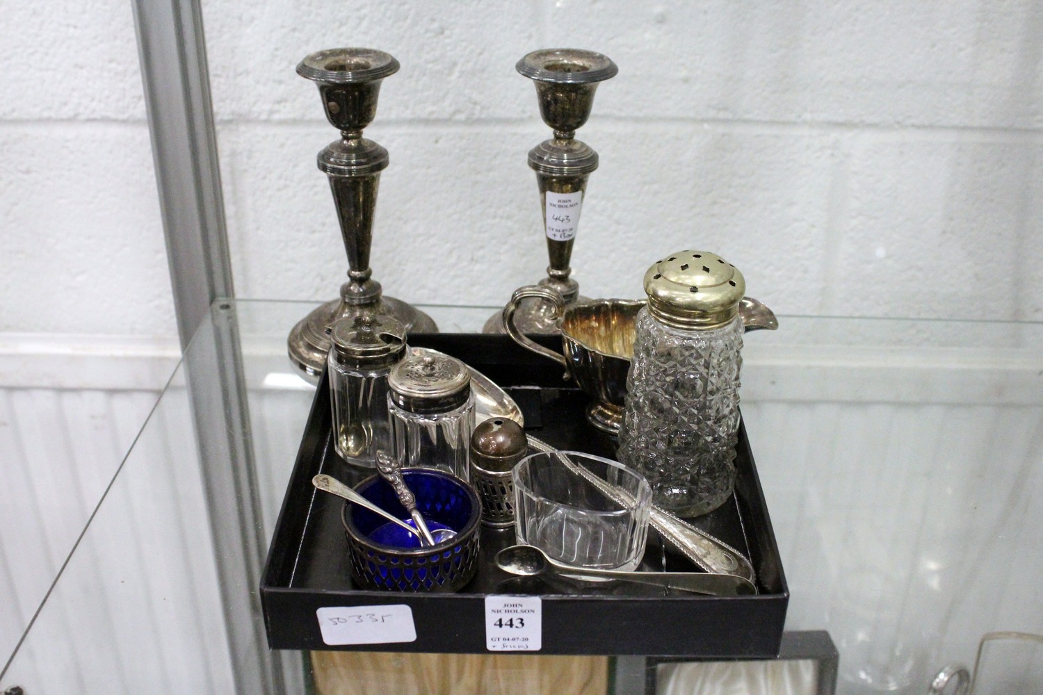 A small group of plated wares to include a pair of candlesticks.
