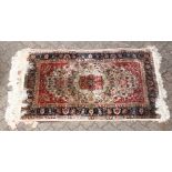A 20th century Persian part silk rug, beige ground with allover floral decoration, within a