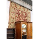 A large rust ground carpet with floral decoration 9ft 6ins x 8ft.