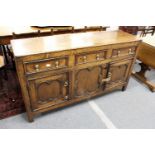 An 18th century oak dresser with three frieze drawers over a central geometric panelled front