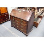 A George III mahogany bureau with fitted interior, two short, three long drawers on ogee bracket