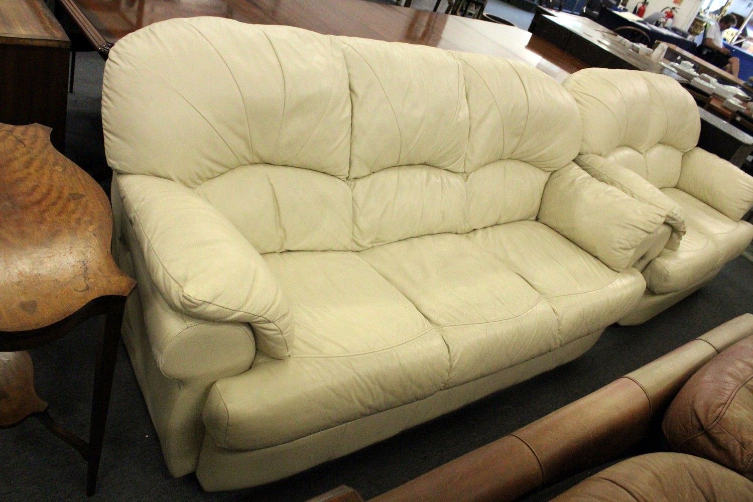 A cream leather three seater settee.