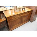 A French fruitwood sideboard with three frieze drawers and two cupboard doors on a plinth base.