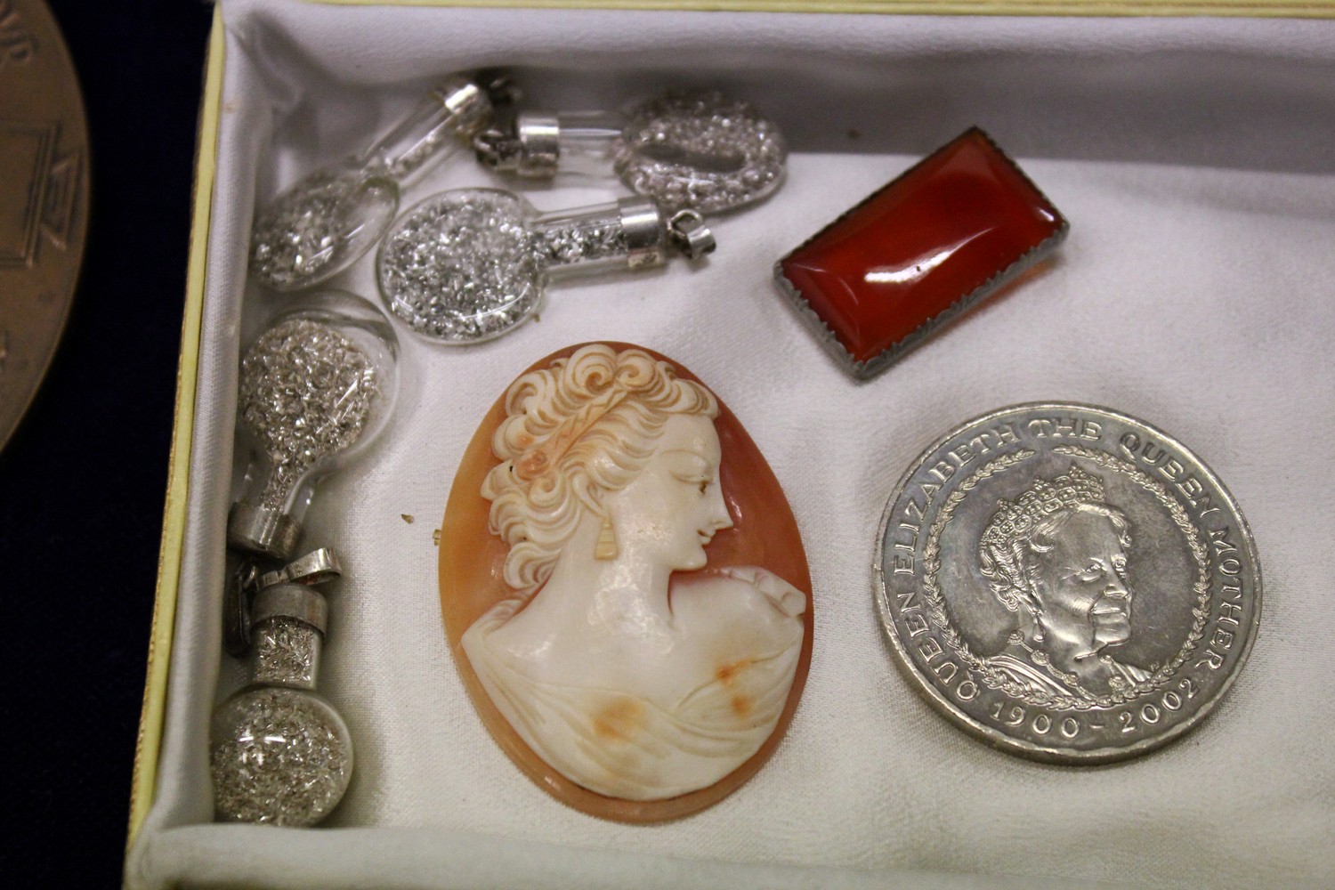 A carved cameo collector's coin and other items.