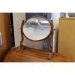A mahogany oval dressing table mirror.