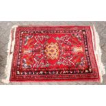 A 20th century Persian rug, bright red ground with floral decoration. 5ft 3ins x 2ft 10ins.