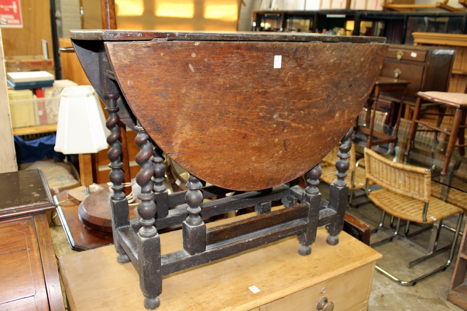 An oak drop leaf, gate leg dining table on barley twist supports.