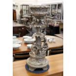 A large decorative silver plated candelabra / centrepiece with figures beneath a palm tree.
