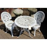 A white painted cast aluminium patio table and pair of chairs.
